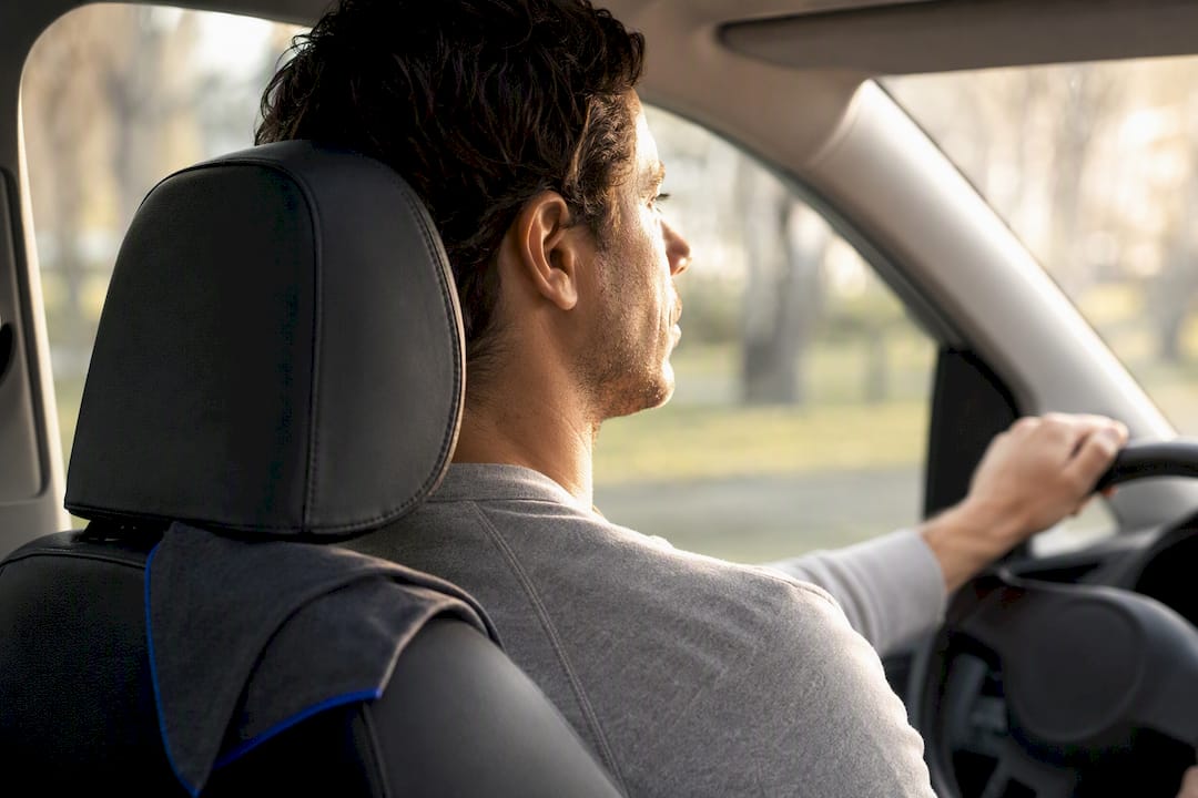 Driver adjusting headrest and seated alignment